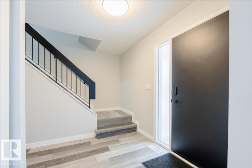 Entrance foyer featuring stairs, wood finished floors, and a textured ceiling - 17808 76 Avenue, Edmonton, AB - Indoor Photo Showing Other Room