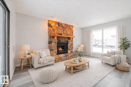 AI generated stage Living room with a stone fireplace and wood finished floors - 17808 76 Avenue, Edmonton, AB - Indoor Photo Showing Living Room With Fireplace