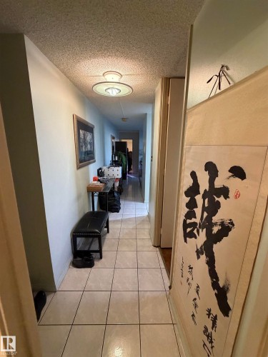 Hallway featuring light tile patterned flooring and a textured ceiling - 1506 10883 Saskatchewan Dr, Edmonton, AB - Indoor Photo Showing Other Room