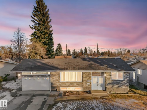 Ranch-style home with stone siding, a shingled roof, driveway, and an attached garage - 13335 106 Street, Edmonton, AB - Outdoor
