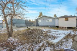 Snow covered rear of property featuring a trampoline - 