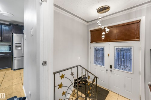 Foyer featuring light tile patterned flooring and ornamental molding - 13335 106 Street, Edmonton, AB - Indoor Photo Showing Other Room
