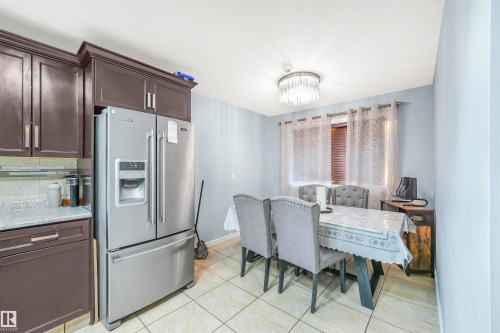 Dining area with a chandelier and light tile patterned floors - 13335 106 Street, Edmonton, AB - Indoor