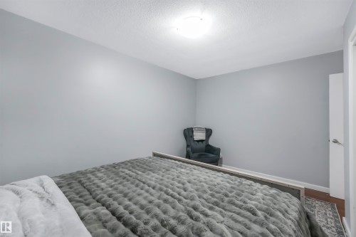 Bedroom featuring a textured ceiling and wood finished floors - 13335 106 Street, Edmonton, AB - Indoor Photo Showing Bedroom