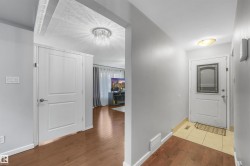 Hallway featuring wood-type flooring and a chandelier - 