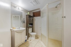 Full bathroom with vanity, light tile patterned flooring, and a shower stall - 
