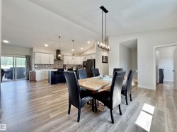 Dining room with lofted ceiling, light wood finished floors, recessed lighting, and a chandelier - 