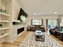 Living room featuring a fireplace, light wood-style flooring, built in features, and recessed lighting - 