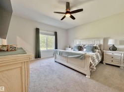 Bedroom featuring light colored carpet and a ceiling fan - 