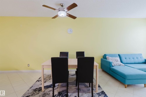 Dining room with light tile patterned floors and ceiling fan - 406 9120 156 Street, Edmonton, AB - Indoor