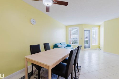 Dining space featuring light tile patterned floors, a textured ceiling, and ceiling fan - 406 9120 156 Street, Edmonton, AB - Indoor Photo Showing Dining Room
