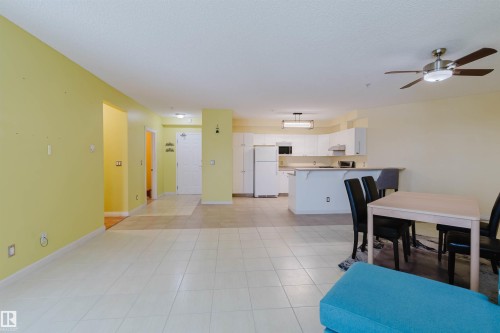 Dining area featuring ceiling fan, light tile patterned floors, and a textured ceiling - 406 9120 156 Street, Edmonton, AB - Indoor Photo Showing Dining Room