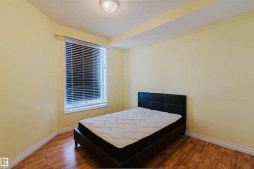 Bedroom featuring wood finished floors and a textured ceiling - 406 9120 156 Street, Edmonton, AB - Indoor Photo Showing Bedroom