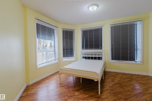 Bedroom featuring wood finished floors and a textured ceiling - 406 9120 156 Street, Edmonton, AB - Indoor