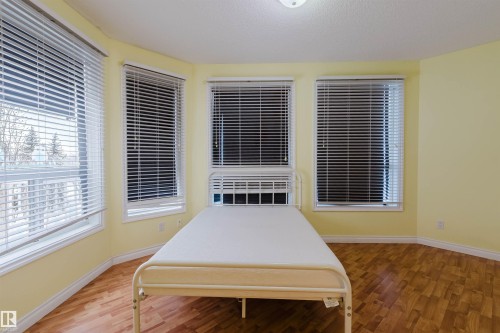 Unfurnished bedroom featuring wood finished floors and a textured ceiling - 406 9120 156 Street, Edmonton, AB - Indoor