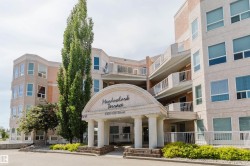 Multi-story building featuring a prominent arched entrance with classical columns - 