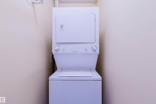 Laundry area featuring stacked washer / dryer - 406 9120 156 Street, Edmonton, AB - Indoor Photo Showing Laundry Room