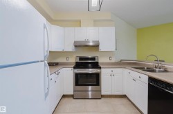 Kitchen with freestanding refrigerator, stainless steel electric range oven, dishwasher, and white cabinets - 