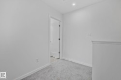 Empty room with light carpet and recessed lighting - 