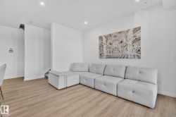 Living area with light wood-type flooring and recessed lighting - 