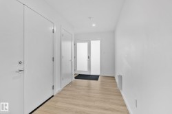 Hall with light wood-type flooring and recessed lighting - 