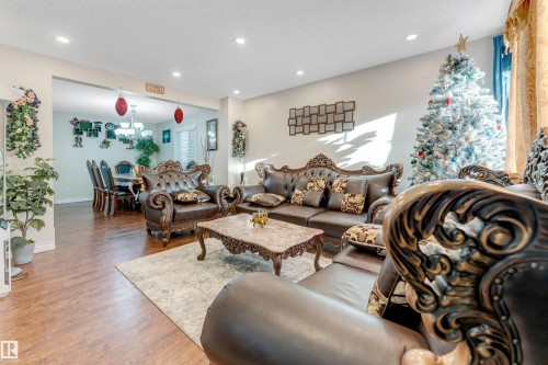 Living area with a textured ceiling, wood finished floors, recessed lighting, and a chandelier - 18404 97A Avenue, Edmonton, AB - Indoor Photo Showing Living Room