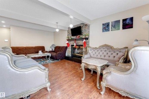 Living area with beamed ceiling, wood finished floors, and a fireplace - 18404 97A Avenue, Edmonton, AB - Indoor With Fireplace
