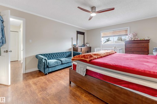 Bedroom with ornamental molding, a textured ceiling, wood finished floors, and a ceiling fan - 18404 97A Avenue, Edmonton, AB - Indoor Photo Showing Bedroom