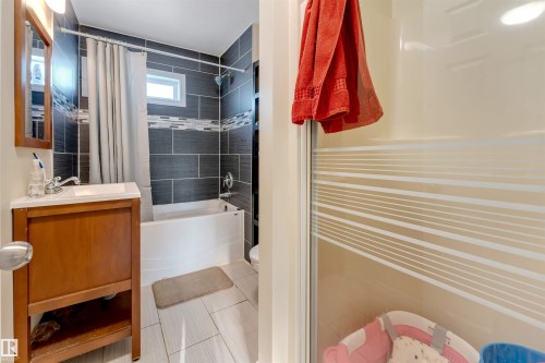 Full bathroom featuring vanity, shower / bath combo with shower curtain, and light tile patterned flooring - 18404 97A Avenue, Edmonton, AB - Indoor Photo Showing Bathroom