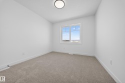 Spare room featuring light carpet and a textured ceiling - 