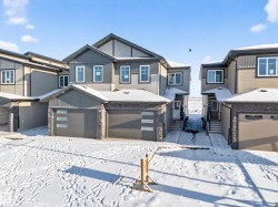 View of front of home with stone siding, a garage, a residential view, and board and batten siding - 