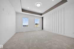 Spare room featuring a raised ceiling, light colored carpet, and recessed lighting - 