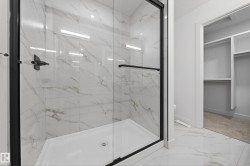 Full bath with light marble finish flooring, a marble finish shower, and a spacious closet - 