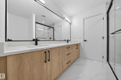 Full bathroom with a marble finish shower, light marble finish flooring, double vanity, and a textured ceiling - 