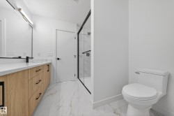 Bathroom with light marble finish floors, a textured ceiling, vanity, and a marble finish shower - 