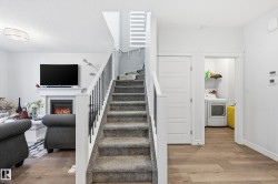 Stairs featuring a glass covered fireplace, washer / clothes dryer, hardwood / wood-style floors, and a textured ceiling - 