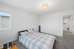 Bedroom featuring multiple windows, carpet floors, and a textured ceiling - 