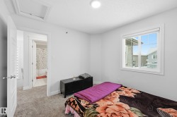 Bedroom with a textured ceiling, carpet floors, and attic access - 