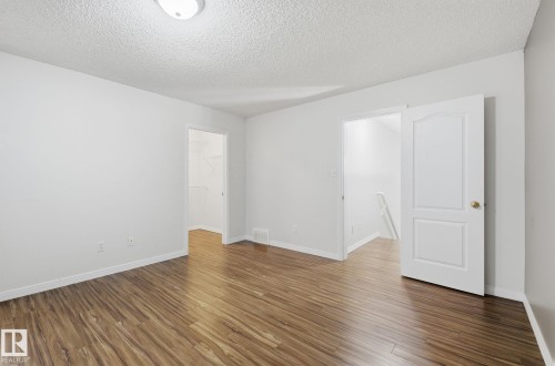Unfurnished room with dark wood finished floors and a textured ceiling - 608 87 St, Edmonton, AB - Indoor Photo Showing Other Room