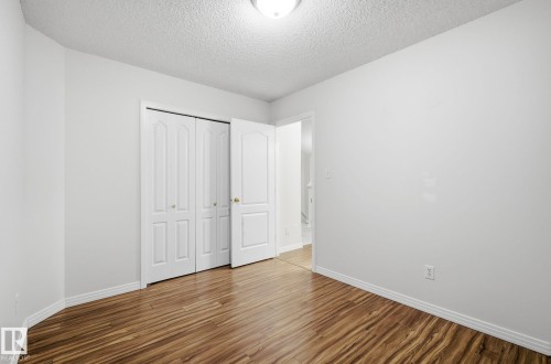 Unfurnished bedroom with wood finished floors, a closet, and a textured ceiling - 608 87 St, Edmonton, AB - Indoor Photo Showing Other Room