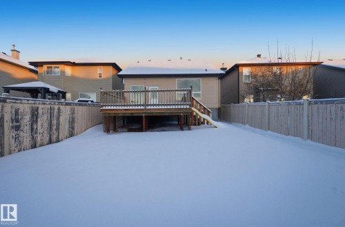 Rear view of house featuring a fenced backyard, a wooden deck, and stairs - 608 87 St, Edmonton, AB - Outdoor