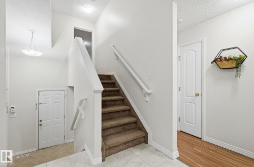 Staircase featuring a textured ceiling and tile patterned floors - 608 87 St, Edmonton, AB - Indoor Photo Showing Other Room