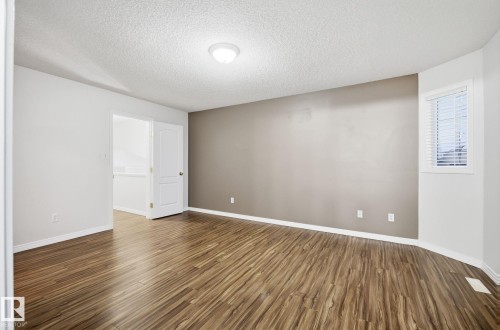 Spare room featuring a textured ceiling and dark wood-style floors - 608 87 St, Edmonton, AB - Indoor Photo Showing Other Room
