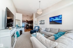 Living area with a chandelier and light colored carpet - 