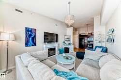 Living area with a glass covered fireplace and a chandelier - 