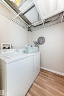 Laundry area featuring light wood-type flooring and separate washer and dryer - 