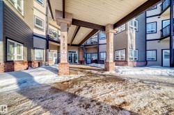 Snow covered property entrance with brick siding - 