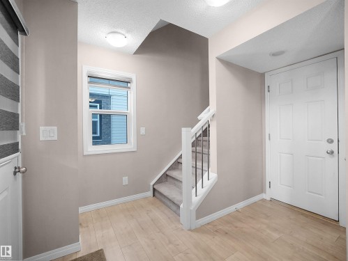 Entryway featuring stairway, light wood-style floors, and a textured ceiling - 2080 Wonnacott Way, Edmonton, AB - Indoor Photo Showing Other Room
