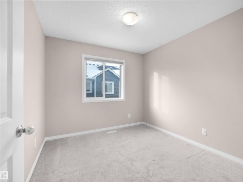 Carpeted spare room featuring baseboards and a textured ceiling - 2080 Wonnacott Way, Edmonton, AB - Indoor Photo Showing Other Room