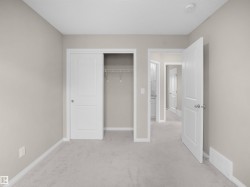 Unfurnished bedroom with light colored carpet and a closet - 
